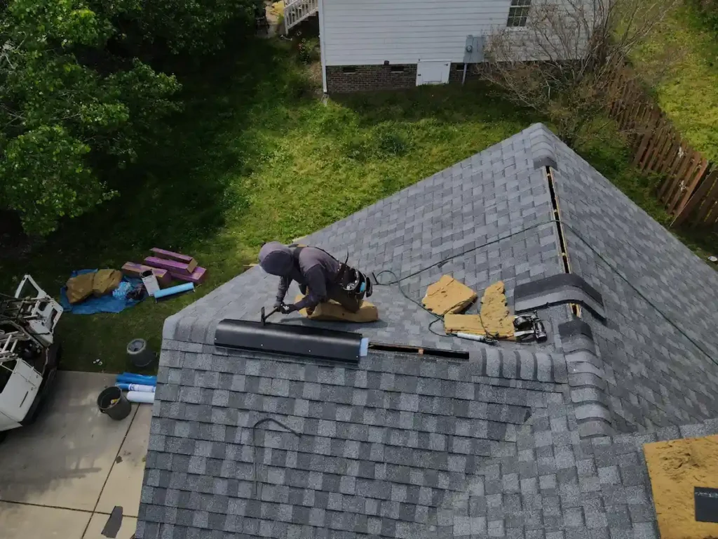 The Importance of Having Filtered Ridge Vent Instead of Unfiltered Ridge Vent 1 Roofing contractor installing filtered ridge vent on asphalt shingle roof during roof replacement